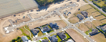 An aerial view of new roads and houses being built in a farming and fruit-growing area.