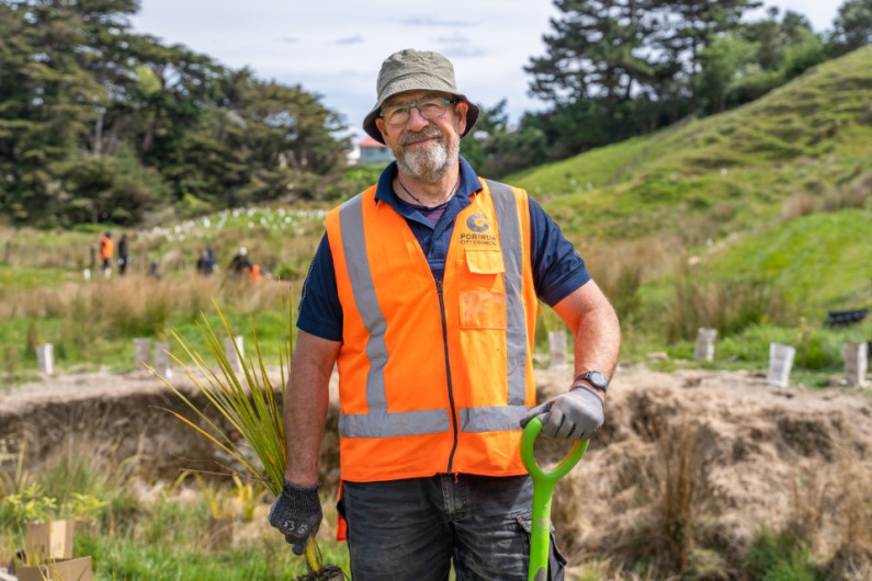 Image of Brian Thomas from Porirua city council planting along a stream