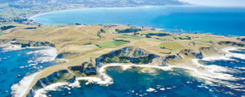 A wide shot of a rocky coastline, surrounded by a deep blue ocean.