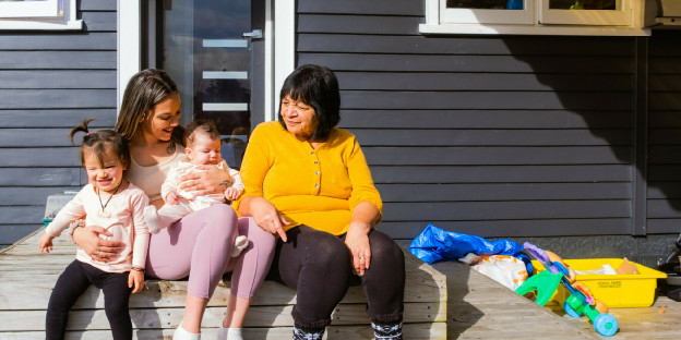 A nan and her family sitting outside a house