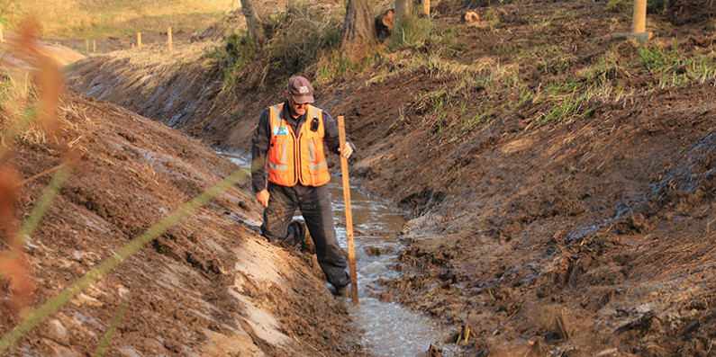 A man in a stream that has been dug out