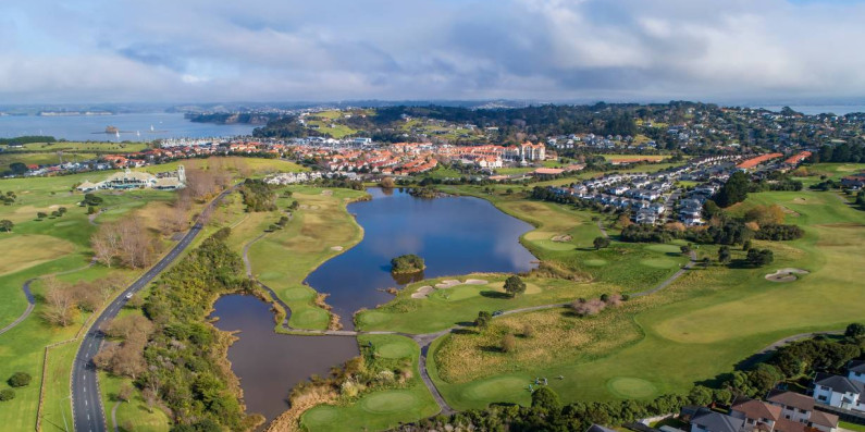 Birds eye view showing housing in the foreground, land with a lake and coastline in the background
