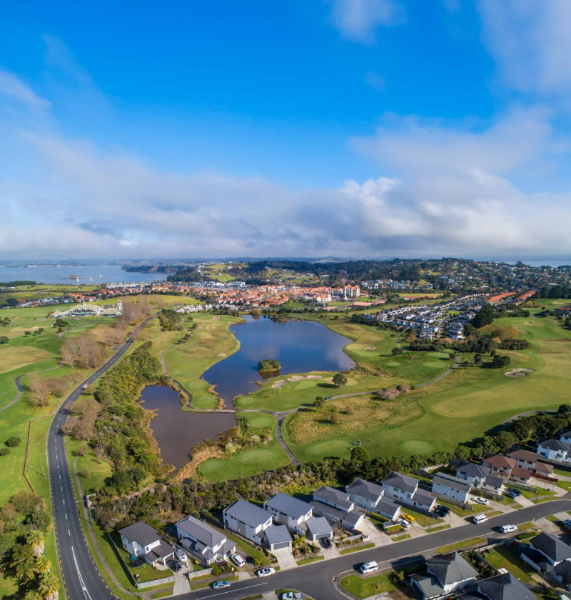 Birds eye view showing housing in the foreground, land with a lake and coastline in the background