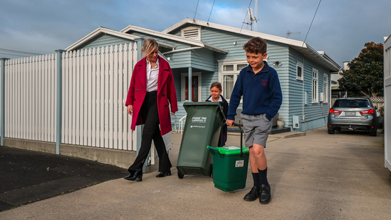 Family taking out food scraps bins to the kerbside for collection