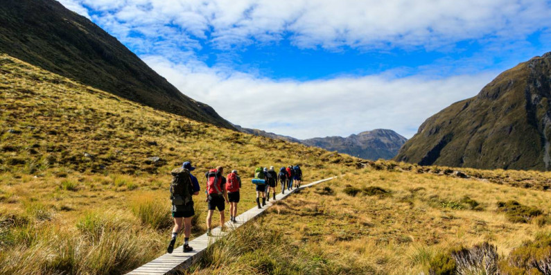 People hiking in the highland on a wooden track
