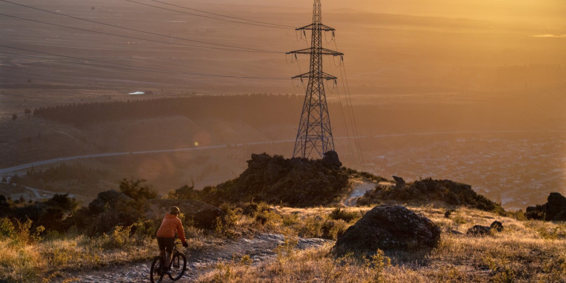Transmission electricity line with a cyclist in the foreground