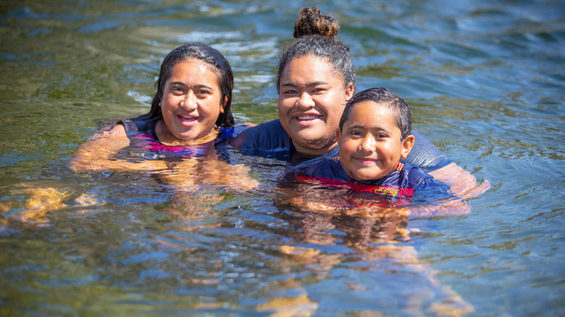 People swimming in water looking at the camera