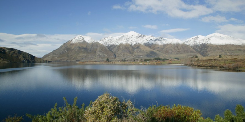 Snow capped mountains with a lake in the foreground