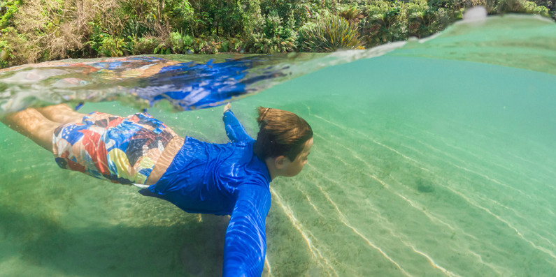 Boy swimming underwater in Lake Tarawera