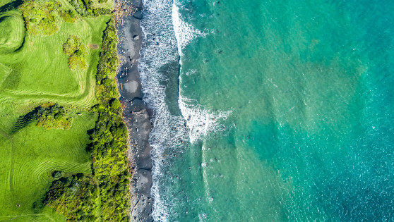 Overhead view of a beach shore and land.