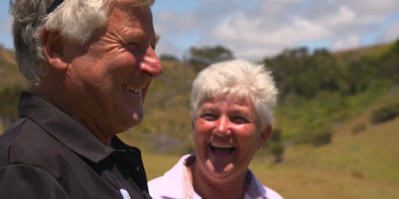 Two people smiling and laughing together on a farm