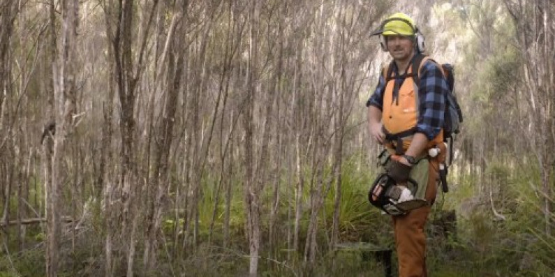 Man holding a chainsaw.