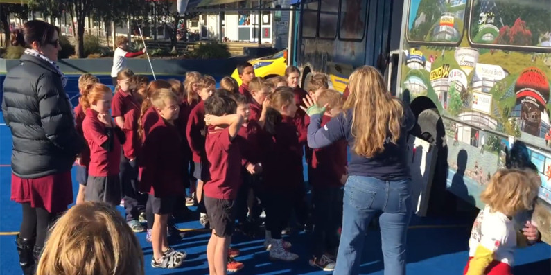 Kids listening to a person telling a story.