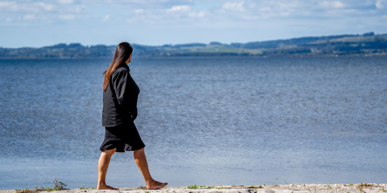 Woman walking around the lake front, Rotorua.